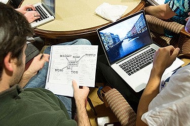 Group of students working together around a table. Group of students working together around table.