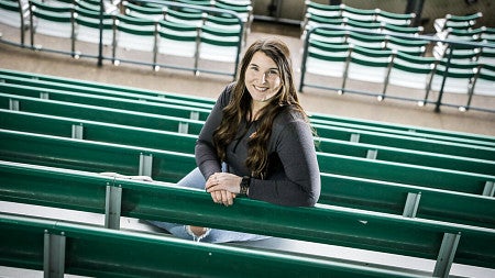 Sammi Costello smiles while seated in a stadium