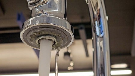 close-up of a standard faucet with running water